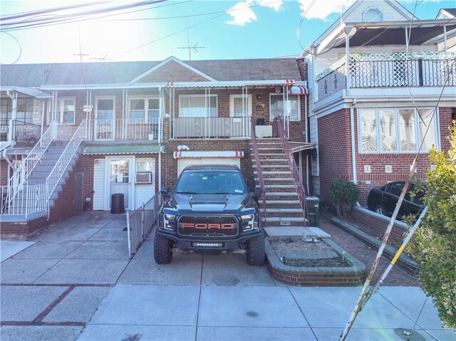 view of front facade featuring concrete driveway, stairway, a porch, and brick siding