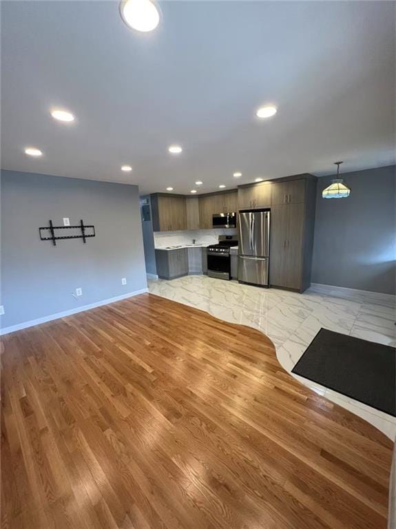 kitchen with recessed lighting, appliances with stainless steel finishes, light countertops, and baseboards