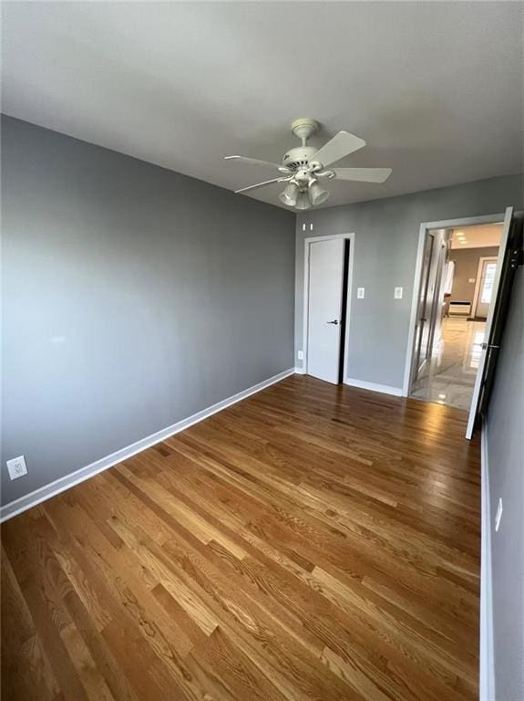 unfurnished bedroom with ceiling fan, baseboards, and wood finished floors