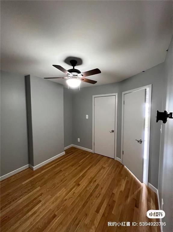 unfurnished bedroom with ceiling fan, baseboards, and wood finished floors