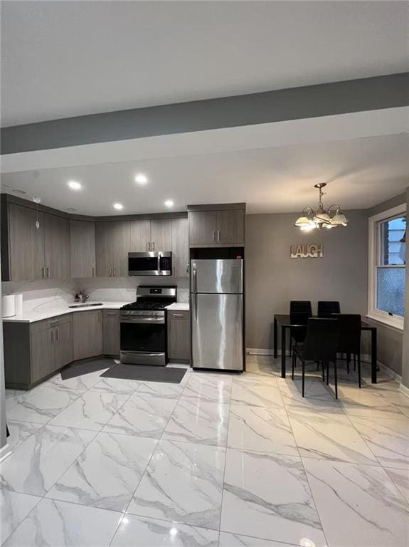1574 E 66th St, Brooklyn, NY 11234 - kitchen featuring stainless steel appliances, light countertops, a chandelier, a sink, and baseboards