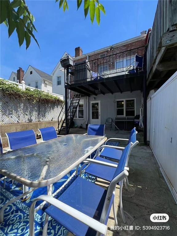 view of patio with outdoor dining space, a balcony, stairs, and a fenced backyard