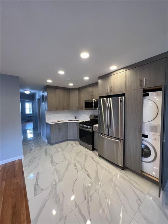 1574 E 66th St, Brooklyn, NY 11234 - kitchen featuring appliances with stainless steel finishes, estacked washer and dryer, light countertops, recessed lighting, and baseboards
