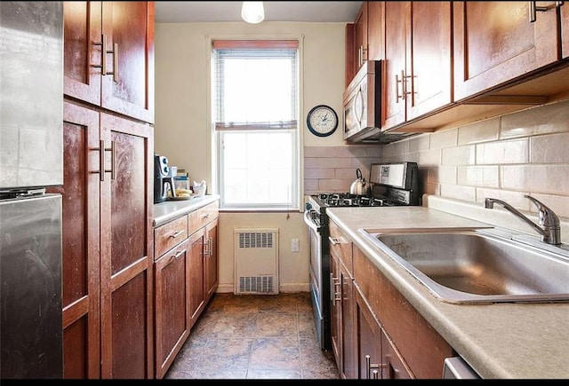 kitchen featuring tasteful backsplash, appliances with stainless steel finishes, and sink