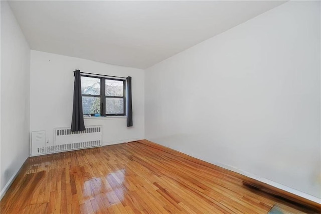 spare room with radiator and hardwood / wood-style floors