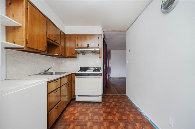 kitchen featuring tasteful backsplash, sink, dark parquet flooring, and gas range gas stove