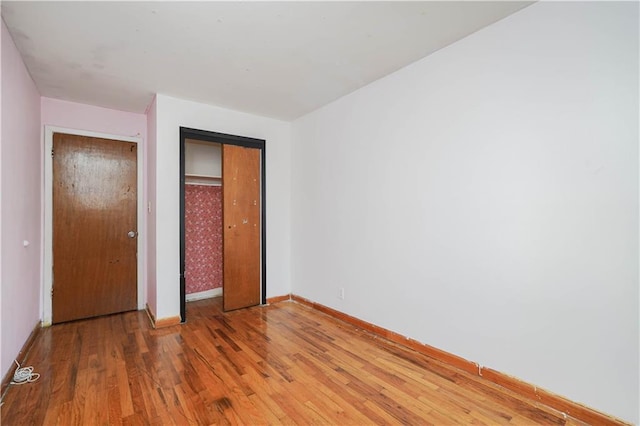 unfurnished bedroom with hardwood / wood-style flooring and a closet