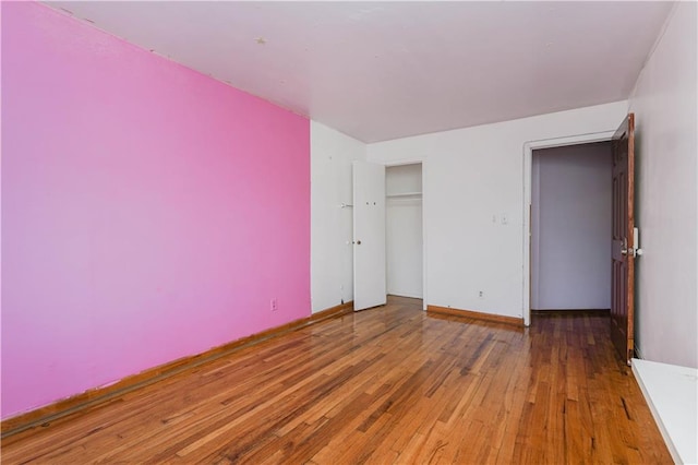 unfurnished bedroom with wood-type flooring and a closet