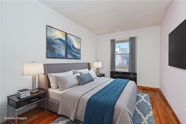 bedroom with dark hardwood / wood-style floors