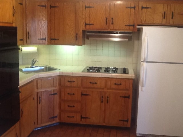 kitchen with tasteful backsplash, sink, white appliances, and tile counters