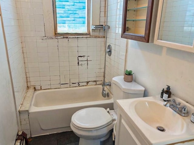 full bathroom with toilet, tile patterned floors, tiled shower / bath, and vanity