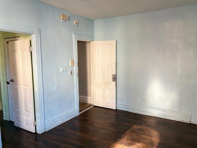 empty room with dark hardwood / wood-style flooring