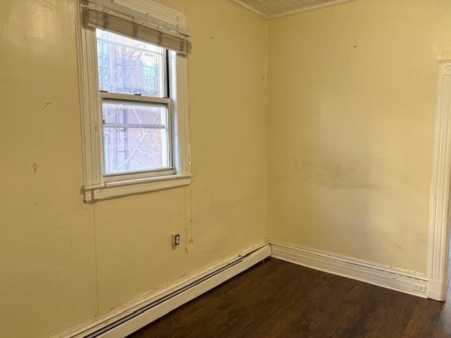 unfurnished room with dark wood-type flooring and a baseboard radiator