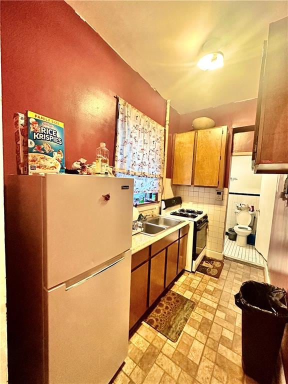 kitchen with fridge, sink, and range with gas cooktop