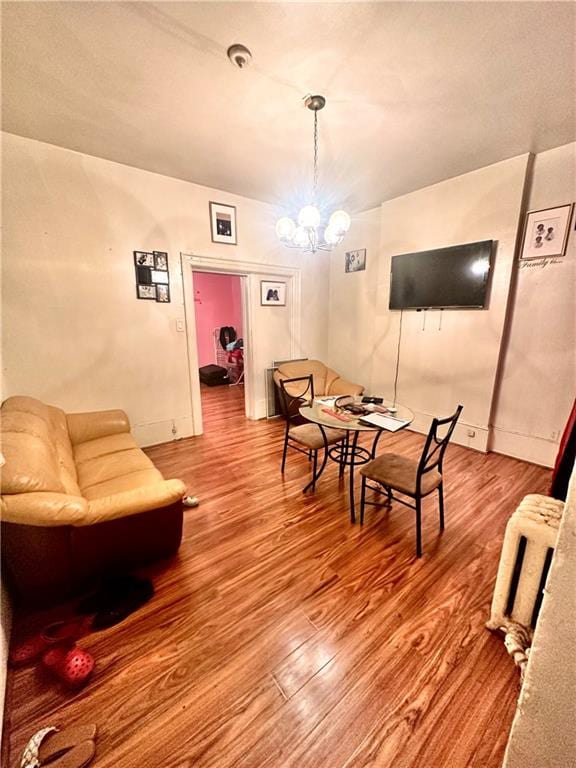 dining space featuring wood-type flooring and a chandelier