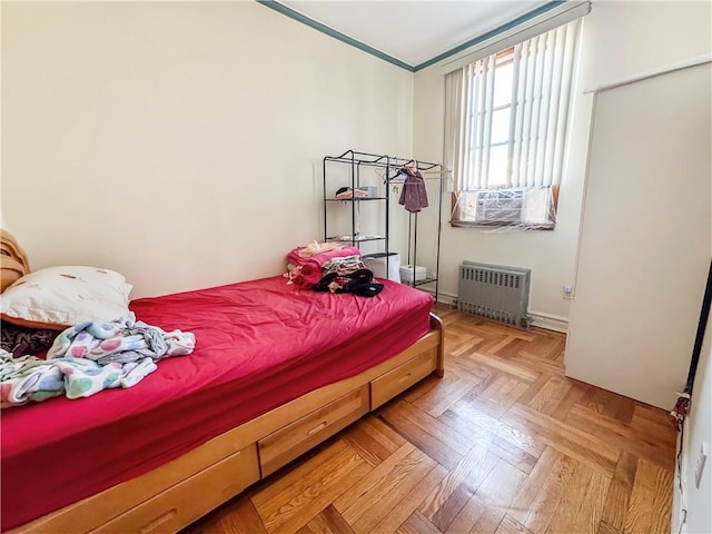 bedroom with cooling unit, light parquet flooring, and radiator