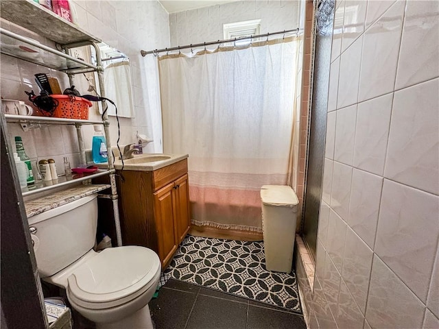 bathroom featuring vanity, tile walls, walk in shower, and toilet