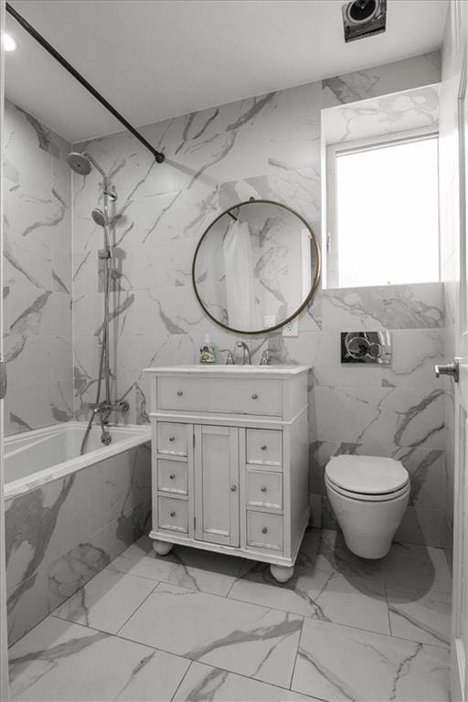 full bathroom featuring tiled shower / bath combo, vanity, and toilet