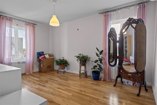 sitting room featuring radiator heating unit and light hardwood / wood-style flooring