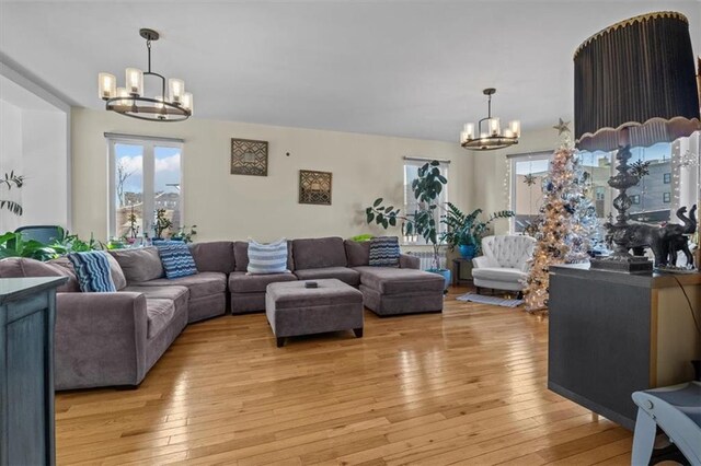 living room featuring light hardwood / wood-style flooring and an inviting chandelier