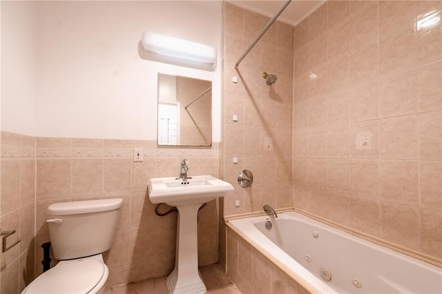 full bathroom with sink, tile walls, toilet, and tiled shower / bath