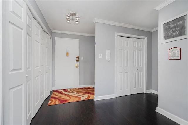 entryway with dark wood-style floors, baseboards, and crown molding