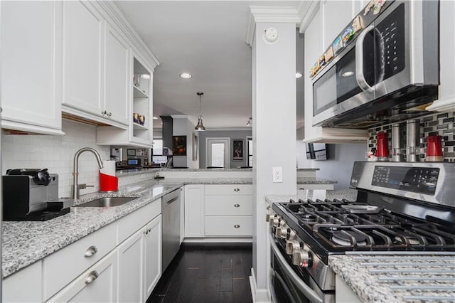 kitchen featuring dark wood-style floors, white cabinets, tasteful backsplash, a sink, and stainless steel appliances
