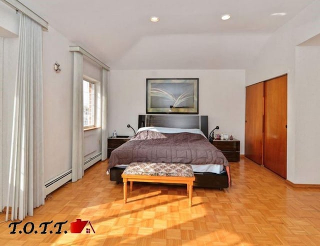 bedroom with light parquet flooring, a baseboard heating unit, a closet, and vaulted ceiling