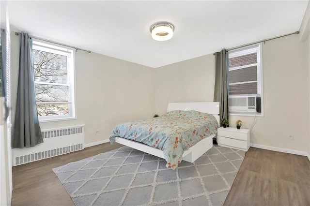 bedroom featuring radiator, cooling unit, and dark hardwood / wood-style flooring