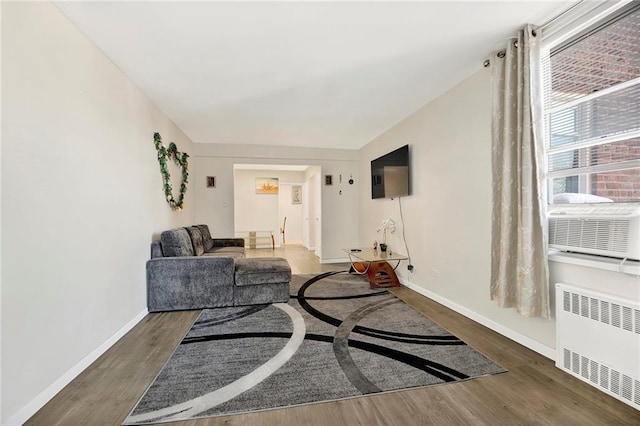 2461 E 29th St Unit 4K, Brooklyn, NY 11235 - living room featuring radiator, wood finished floors, baseboards, and cooling unit