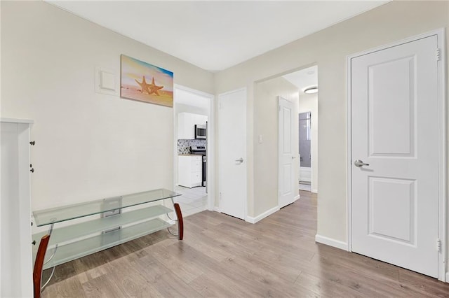 corridor with light hardwood / wood-style flooring