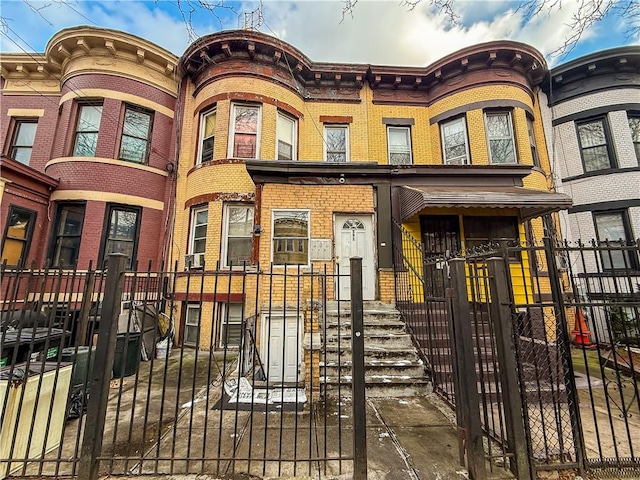 multi unit property featuring a fenced front yard and brick siding