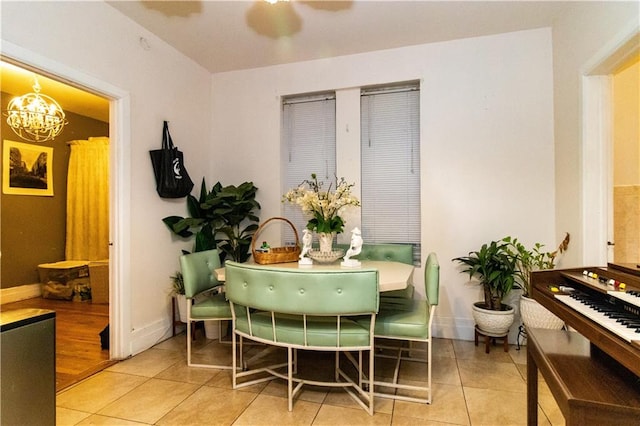 dining area featuring light tile patterned floors and a notable chandelier