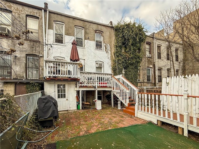 rear view of property with stairs, fence, a wooden deck, a patio area, and stucco siding