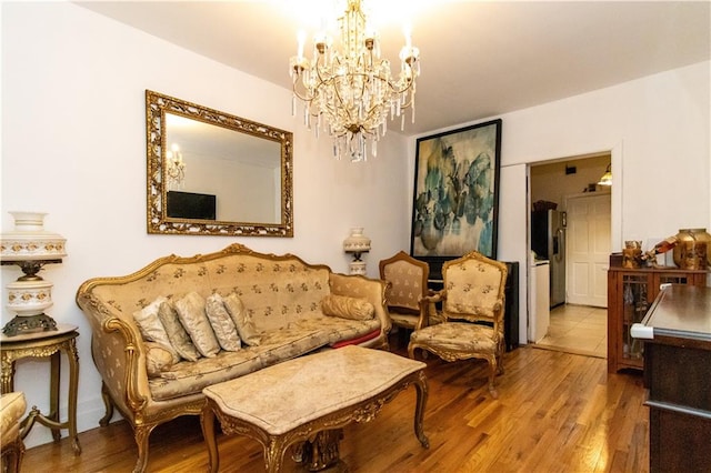 living area with wood finished floors and a notable chandelier