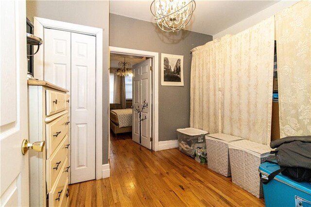 mudroom with hardwood / wood-style flooring and an inviting chandelier