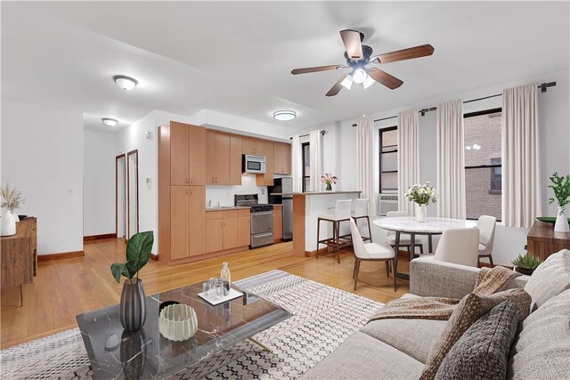 living room with ceiling fan and light wood-type flooring