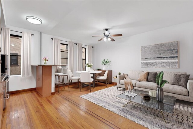 living room with ceiling fan and light hardwood / wood-style flooring