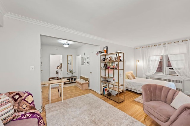 living area featuring ornamental molding, cooling unit, wood finished floors, and radiator