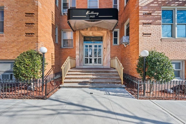 view of exterior entry with french doors and brick siding