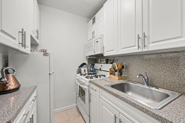 kitchen with tasteful backsplash, light tile patterned flooring, a sink, white cabinetry, and white appliances