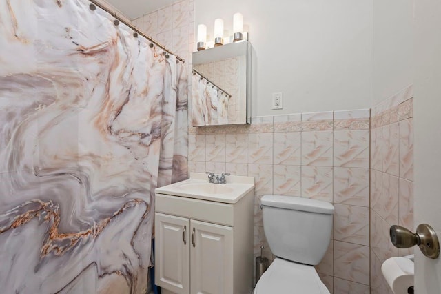 full bath with toilet, curtained shower, tile walls, and vanity