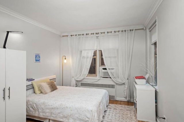 bedroom featuring radiator heating unit, ornamental molding, and wood finished floors