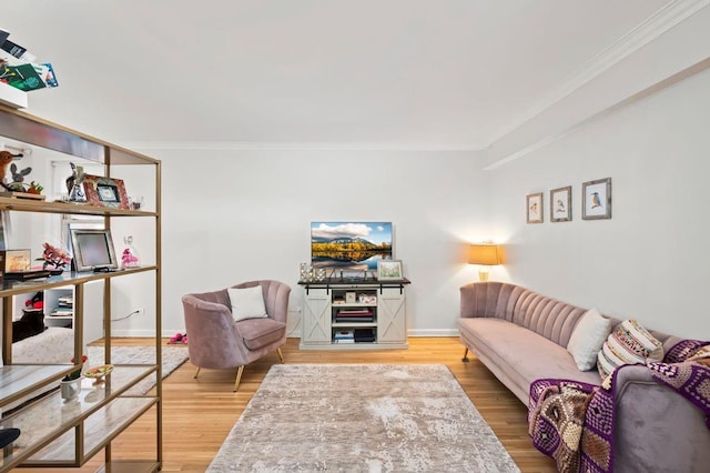 living area with ornamental molding, wood finished floors, and baseboards