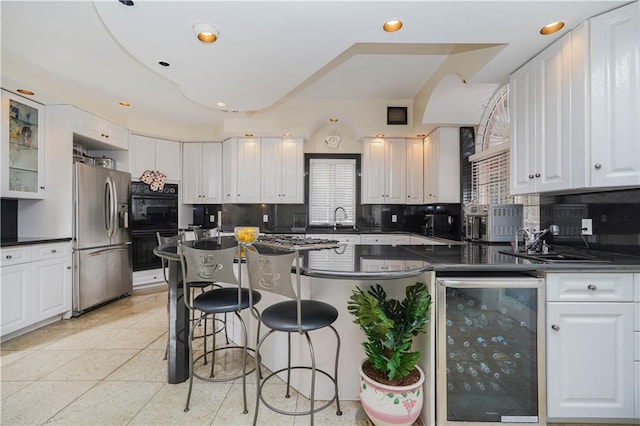 kitchen featuring dark countertops, decorative backsplash, white cabinets, beverage cooler, and stainless steel fridge with ice dispenser