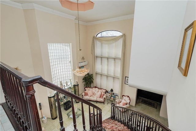 staircase featuring ornamental molding, a healthy amount of sunlight, and a tiled fireplace