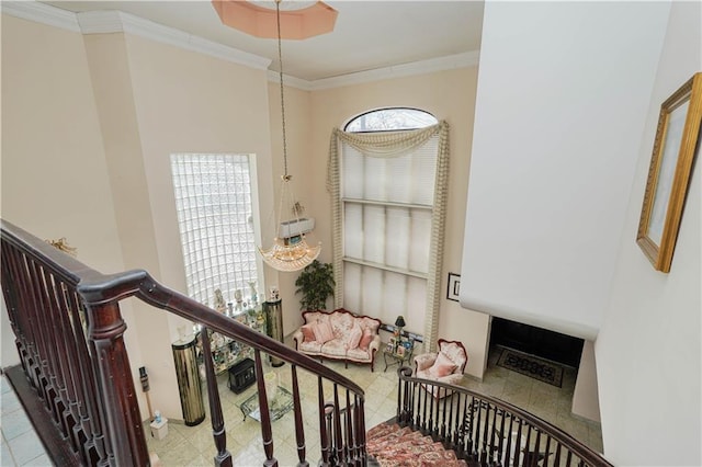 stairs featuring crown molding, a high ceiling, and a fireplace