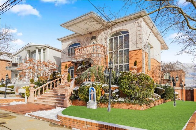 view of front of home featuring a front yard and a balcony