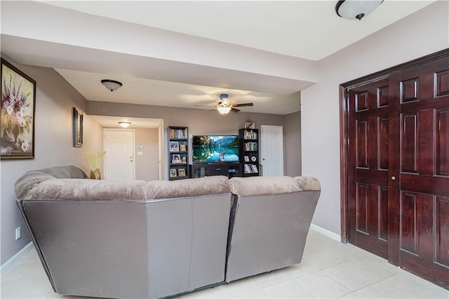 living room featuring baseboards, ceiling fan, and light tile patterned floors