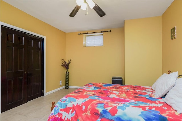 bedroom featuring light tile patterned floors, baseboards, and a ceiling fan